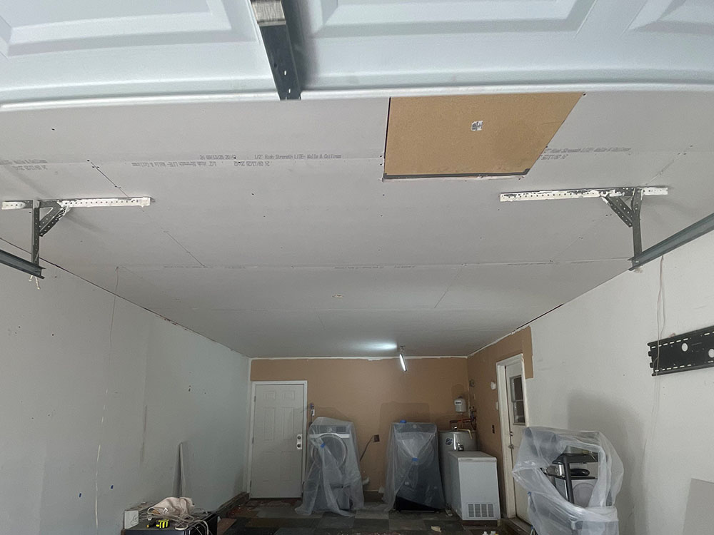 1/2-inch UltraLight drywall panels hung tight to ceiling joists around garage door tracks